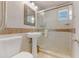 Bathroom with a pedestal sink and glass enclosed shower with decorative tile accents at 3326 S Peninsula Dr, Port Orange, FL 32127