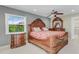 Primary bedroom featuring elegant wood furniture and a window view of the landscape at 3326 S Peninsula Dr, Port Orange, FL 32127