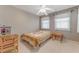 Neutral bedroom with light gray walls, tiled flooring, and a cozy bed with floral blanket at 3326 S Peninsula Dr, Port Orange, FL 32127