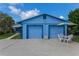 Stylish blue home with a two-car garage, an umbrella-covered table and chairs at 3326 S Peninsula Dr, Port Orange, FL 32127