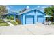 Charming blue home featuring a two-car garage and well-manicured landscaping at 3326 S Peninsula Dr, Port Orange, FL 32127