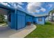 Rear view of a blue home with a covered patio and well-kept lawn at 3326 S Peninsula Dr, Port Orange, FL 32127