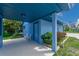 Cozy blue home with a covered patio, lush greenery, and a comfortable seating area at 3326 S Peninsula Dr, Port Orange, FL 32127