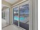 View of the screened-in pool and patio area from inside the home through sliding glass doors at 3326 S Peninsula Dr, Port Orange, FL 32127