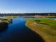 Aerial view of a golf course with a lake and trees in the upscale Venetian Bay community at 3577 Maribella Dr, New Smyrna Beach, FL 32168
