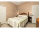 Bedroom featuring a wooden headboard bed, light green bedding, neutral walls and white door and trim at 3577 Maribella Dr, New Smyrna Beach, FL 32168