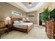 Inviting bedroom with a tray ceiling, wood furnishings, tile floors, and ample natural light at 3577 Maribella Dr, New Smyrna Beach, FL 32168