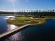 Scenic aerial view of the golf course with a bridge and serene lake in the community at 3577 Maribella Dr, New Smyrna Beach, FL 32168