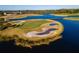 Aerial shot of a golf course with lakes, sand traps, and manicured greens at Venetian Bay at 3577 Maribella Dr, New Smyrna Beach, FL 32168
