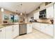 Open kitchen with stainless steel appliances, granite countertops, white cabinets, and tile flooring at 3577 Maribella Dr, New Smyrna Beach, FL 32168