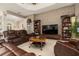 The living room features a stone wall, large screen television, leather furniture, and tile flooring at 3577 Maribella Dr, New Smyrna Beach, FL 32168