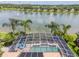 Aerial view of the screened-in pool and spa overlooking a scenic lake with a fountain at 3577 Maribella Dr, New Smyrna Beach, FL 32168