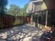 Outdoor patio area with brick pavers, colorful chairs, and view of an enclosed sunroom and wooded area at 38 Cedar Dunes Dr, New Smyrna Beach, FL 32169