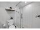 Bathroom with a glass-enclosed shower featuring white tile and black and white decorative accent floor at 4151 S Atlantic Ave # 3090, New Smyrna Beach, FL 32169