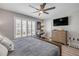 Light bedroom with a large window, a ceiling fan, and a comfortable bed with a blue quilt at 4151 S Atlantic Ave # 3090, New Smyrna Beach, FL 32169