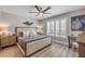 Bright bedroom with a ceiling fan, large windows with shutters, and a plush bed with decorative pillows at 4151 S Atlantic Ave # 3090, New Smyrna Beach, FL 32169