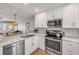 Modern kitchen with stainless steel appliances, marble countertops, and open view to the living area at 4151 S Atlantic Ave # 3090, New Smyrna Beach, FL 32169