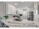 Bright kitchen featuring stainless steel appliances, marble countertops, and white cabinetry at 4151 S Atlantic Ave # 3090, New Smyrna Beach, FL 32169