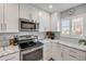 Well-lit kitchen with white cabinets, stainless steel appliances, and marble countertops at 4151 S Atlantic Ave # 3090, New Smyrna Beach, FL 32169