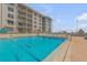Large swimming pool with ocean views in a condominium complex with lounge chairs and shade at 4151 S Atlantic Ave # 3090, New Smyrna Beach, FL 32169