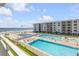 View of the beach, ocean, pool deck, and swimming pools from the balcony of this condo building at 4151 S Atlantic Ave # 3090, New Smyrna Beach, FL 32169