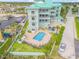 Overhead shot of mint green condominium complex, featuring a pool, parking, and lovely landscaping at 423 S Atlantic Ave # 301, New Smyrna Beach, FL 32169