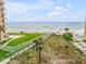Scenic beach access with a walkway, dune grass, and ocean views from a grassy area at 423 S Atlantic Ave # 301, New Smyrna Beach, FL 32169