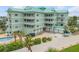 Stunning condominium exterior showcasing multiple balconies, a private pool, and ample parking at 423 S Atlantic Ave # 301, New Smyrna Beach, FL 32169