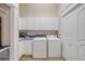 Functional laundry room with washer, dryer, cabinets, utility sink, and bi-fold doors at 423 S Atlantic Ave # 301, New Smyrna Beach, FL 32169