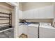 Functional laundry room with washer, dryer, cabinets, utility sink, wine cooler, and bi-fold doors at 423 S Atlantic Ave # 301, New Smyrna Beach, FL 32169