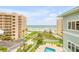 Breathtaking ocean view with palm trees, lawn, and neighboring buildings from the condominium at 423 S Atlantic Ave # 301, New Smyrna Beach, FL 32169