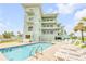 Relaxing pool area with lounge chairs, attached to the mint green condominium complex by the ocean at 423 S Atlantic Ave # 301, New Smyrna Beach, FL 32169