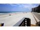 View of sandy beach with an ocean and condos in the background, as seen from a walkway at 4435 S Atlantic Ave # 416, Port Orange, FL 32127