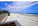 View of a sandy beach from a walkway showing the ocean, blue sky, and beachside condos at 4435 S Atlantic Ave # 416, Port Orange, FL 32127