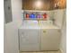 Laundry room includes a full-size washer, dryer, shelves, and overhead cabinets at 4435 S Atlantic Ave # 416, Port Orange, FL 32127