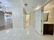 Hallway with white tile flooring leads to a well-lit bathroom, with additional rooms visible at 4575 S Atlantic Ave # 6203, Ponce Inlet, FL 32127