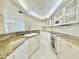 White kitchen featuring granite countertops, white cabinetry, and stainless steel appliances at 4575 S Atlantic Ave # 6203, Ponce Inlet, FL 32127