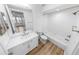 Bright bathroom featuring wood-look floors, white tile, and a white vanity at 4620 Riverwalk Village Ct # 7403, Ponce Inlet, FL 32127
