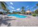 Inviting community pool area with palm trees, lounge chairs, and a gazebo at 4620 Riverwalk Village Ct # 7403, Ponce Inlet, FL 32127