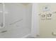 Bright bathtub and shower featuring safety grab bars, shell decor and a shower curtain at 511 Mount Olympus Blvd, New Smyrna Beach, FL 32168