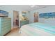 Comfortable bedroom featuring coastal decor, a queen bed, and en suite bathroom access at 511 Mount Olympus Blvd, New Smyrna Beach, FL 32168