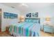 Inviting bedroom with a queen bed, soft striped bedding, and beach-themed decor at 511 Mount Olympus Blvd, New Smyrna Beach, FL 32168