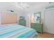 Light and airy bedroom with striped bedding, and coordinating green dresser at 511 Mount Olympus Blvd, New Smyrna Beach, FL 32168