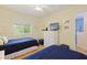 Sunny bedroom with twin beds, window view, and a dresser with beach-themed decor at 511 Mount Olympus Blvd, New Smyrna Beach, FL 32168