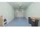 Spacious single-car garage with concrete block walls, blue epoxy floor, and white door at 511 Mount Olympus Blvd, New Smyrna Beach, FL 32168