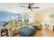 Bright living room with a ceiling fan, comfortable seating, and a view to the dining area at 511 Mount Olympus Blvd, New Smyrna Beach, FL 32168
