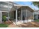 View of screened porch with white pillars, concrete floors, and chairs on the outside of the house at 511 Mount Olympus Blvd, New Smyrna Beach, FL 32168