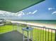 Relax on the balcony with ocean views, white railings, and clear blue skies above at 5201 S Atlantic Ave # 407A, New Smyrna Beach, FL 32169