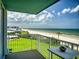 Balcony view of the ocean, white railings, and green lawn below, perfect for relaxing at 5201 S Atlantic Ave # 407A, New Smyrna Beach, FL 32169