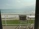 Balcony with ocean view, white chair and table at 5201 S Atlantic Ave # 407A, New Smyrna Beach, FL 32169